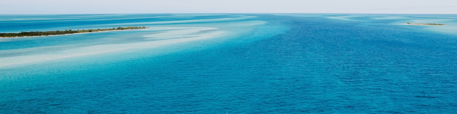 Aerial of Sailboat Sailing Between Islands in Turquoise Water