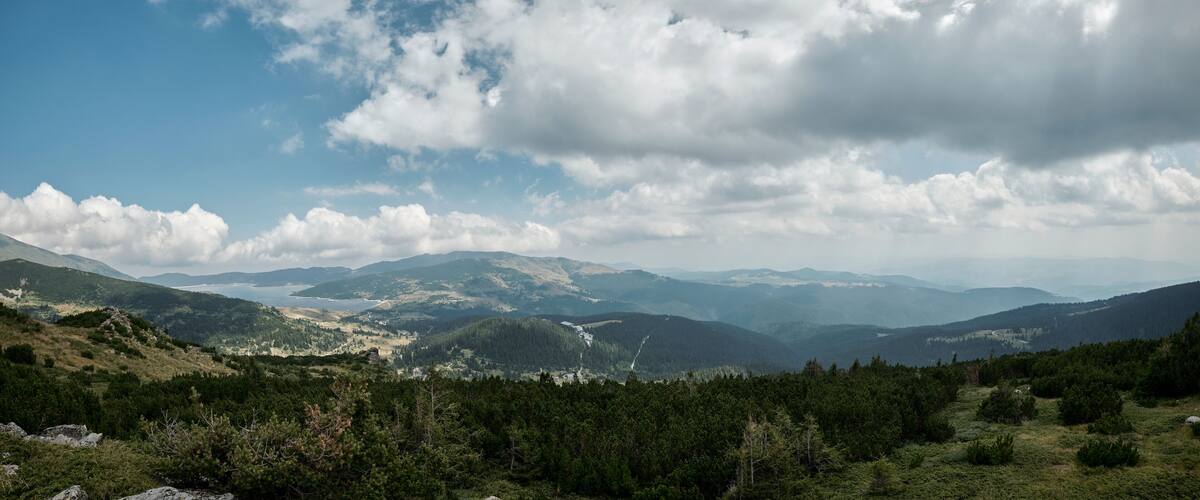A mountainous landscape with dense forests and a winding river.