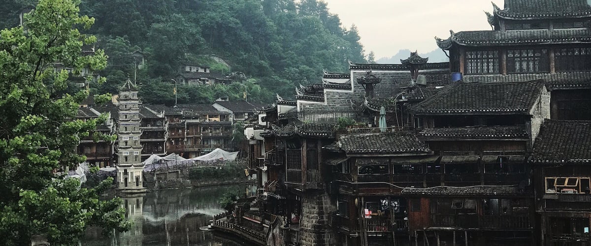 Un pueblo tradicional chino con edificios de madera y un río.