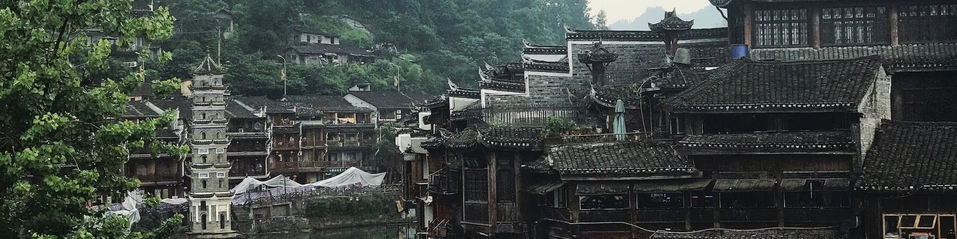 A traditional Chinese village with wooden buildings and a river.