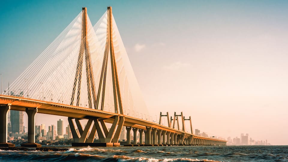 A cable-stayed bridge with a city skyline in the background.