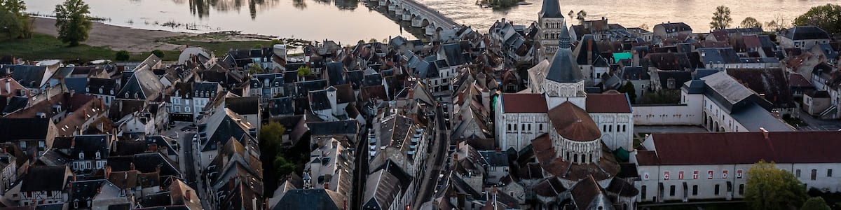 A river flowing through a town with historic buildings and a prominent church spire.