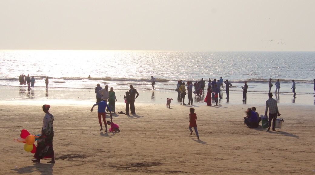 Juhu Beach mostrando una playa y un atardecer y también un gran grupo de personas