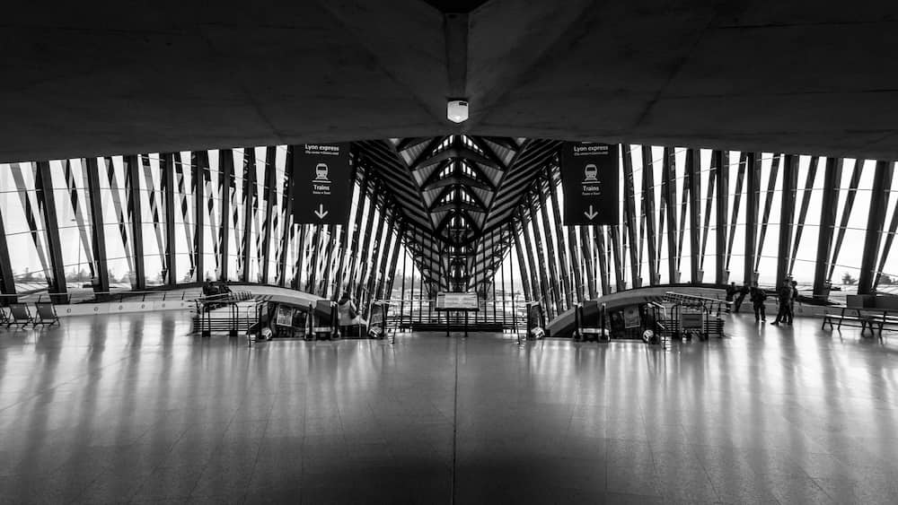 Une gare moderne avec un plafond haut et de grandes fenêtres.