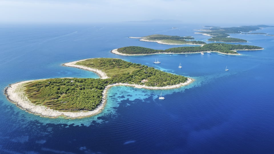 A chain of lush green islands surrounded by clear blue waters.