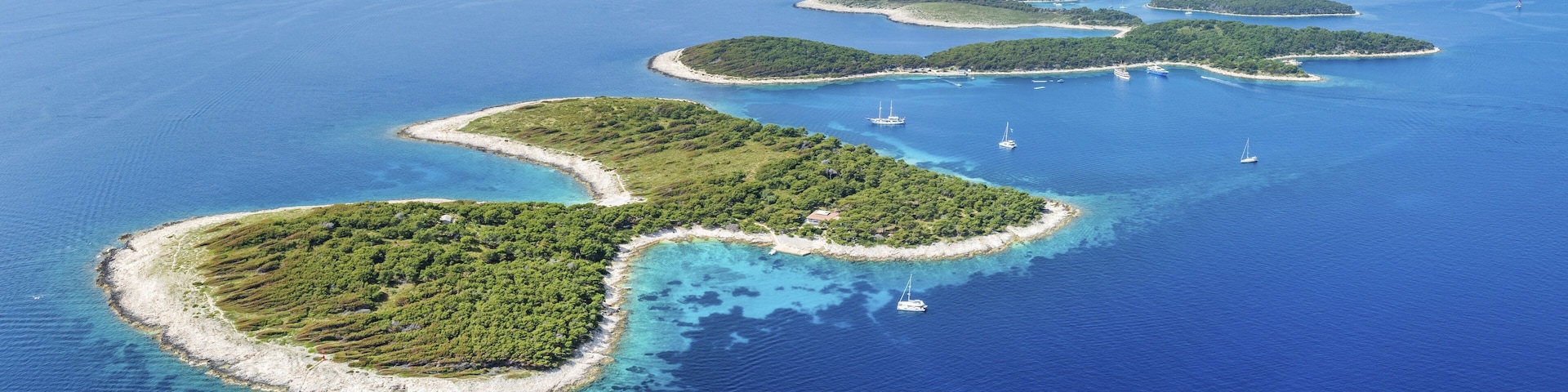 A chain of lush green islands surrounded by clear blue waters.