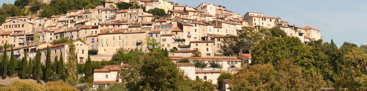 A hillside town with historic buildings, a prominent church tower, and lush greenery.