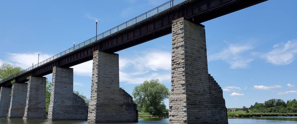 A stone bridge over a river with a clear sky.