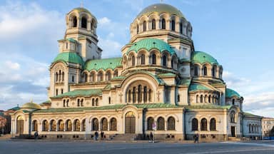 Una catedral grande y ornamentada, con múltiples cúpulas y ventanas de arco.