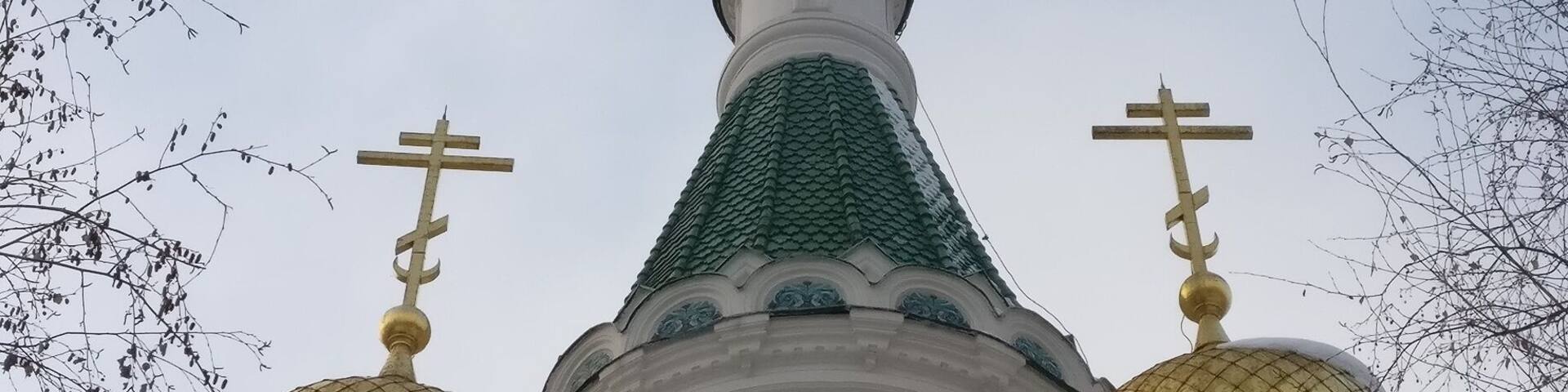A church with three golden domes and crosses on top.