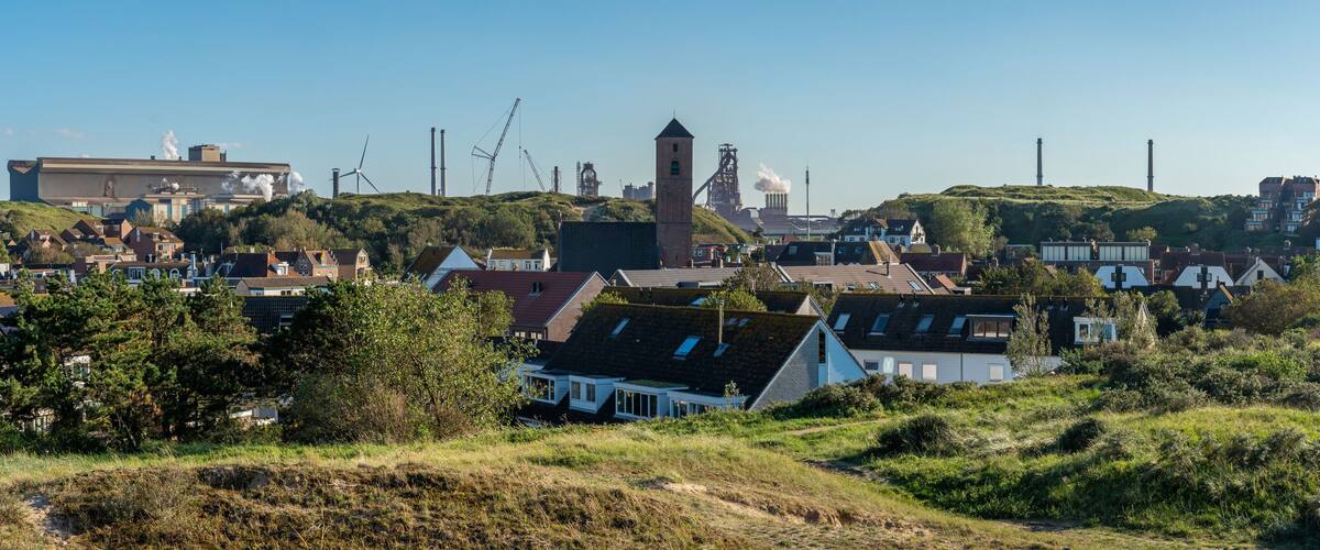 A coastal town with wind turbines, a church, and residential buildings.