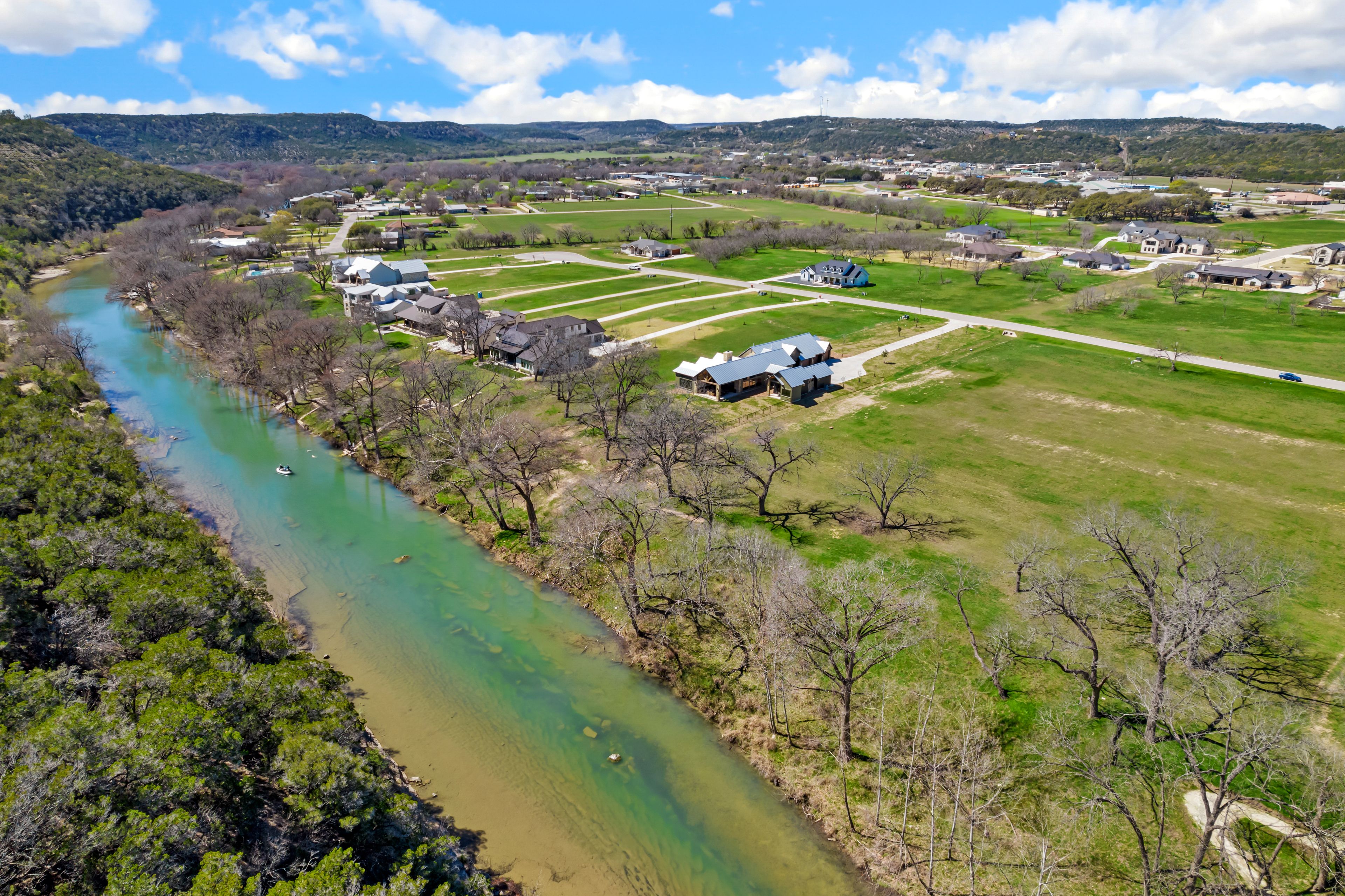 Un río serpentea por un paisaje rural con casas y campos.