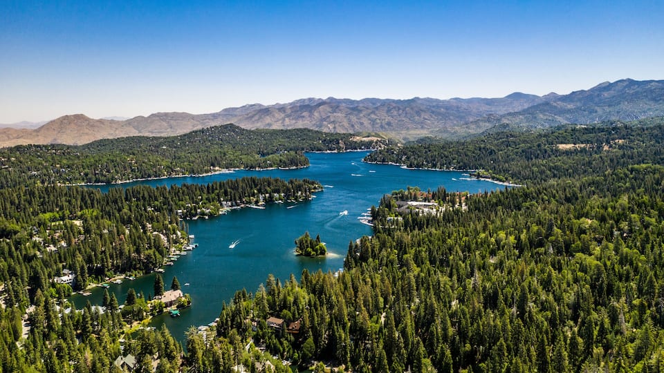 A lake surrounded by dense forests and mountains.