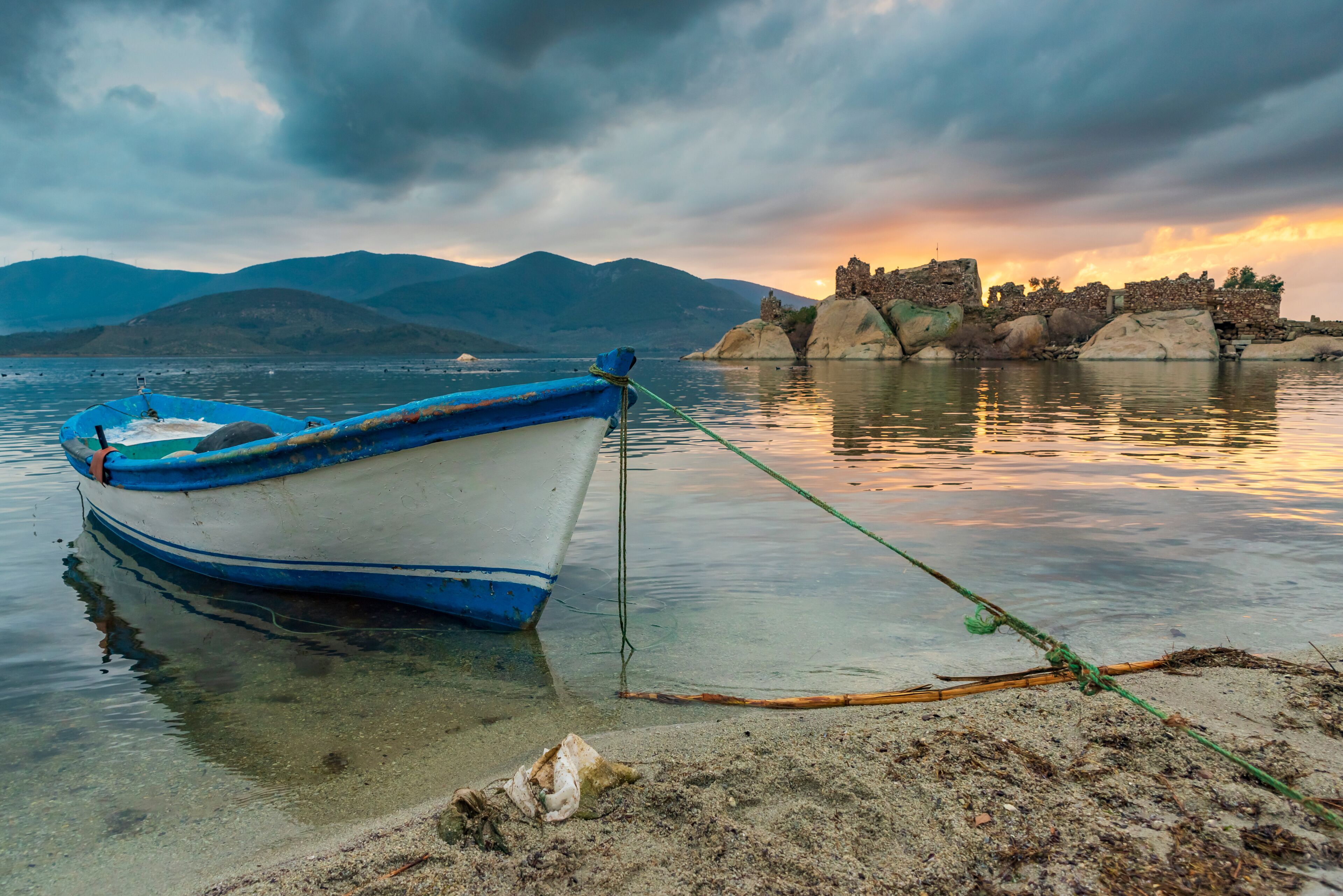 Different views of Bafa Lake in Aegean province of Turkey, boats pier island with monastery and rock forms on a colorful sunset and reflections