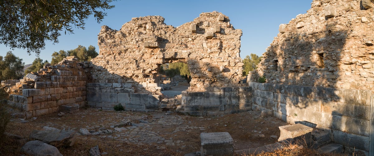 Ancient ruins with stone walls and scattered stones.