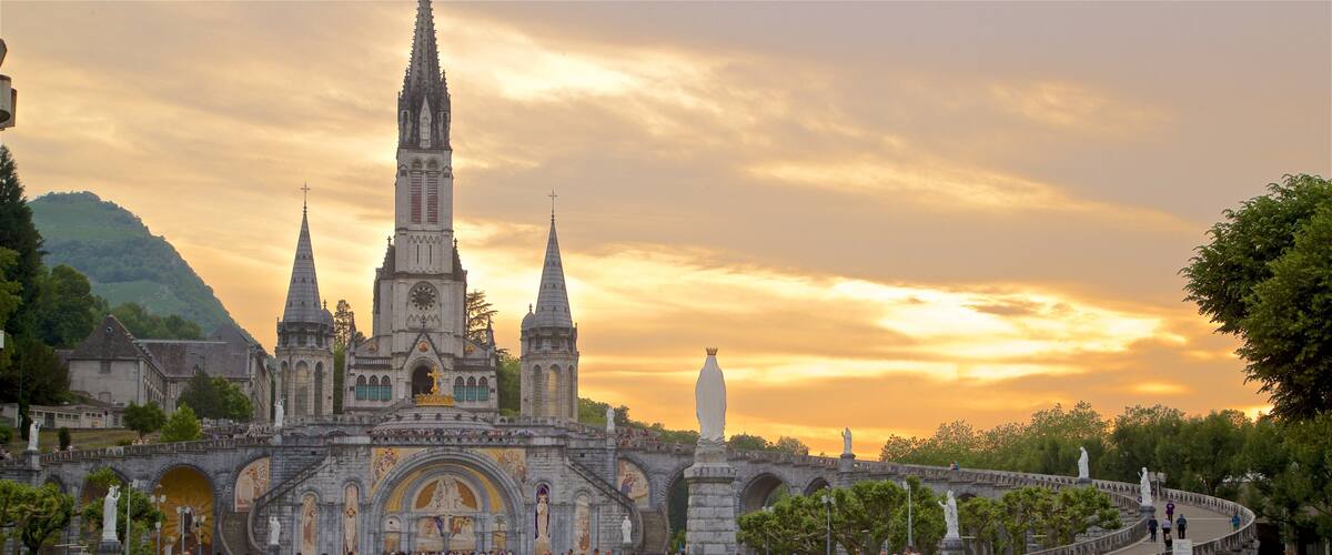 A historic cathedral with a tall spire and a bridge leading to it.