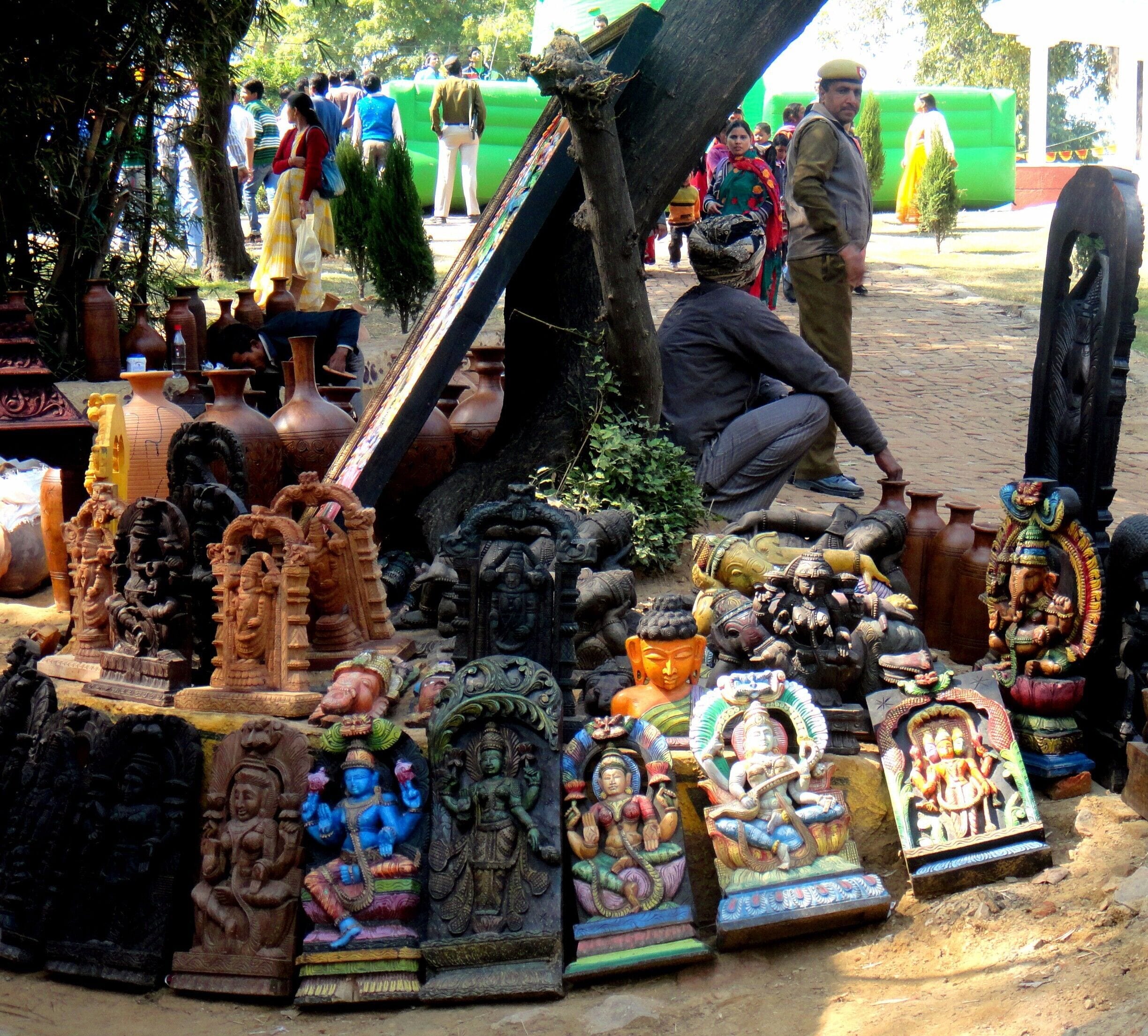 Surajkund Fair – It is an international crafts fair that is held in Faridabad, India, every year in the month of February. Crowded and colorful. You get everything ranging from a key-ring to bed sheets.

This guy is selling sculptures of Indian Gods while the cop keeps an eye on him. There is Ganesh, Buddha and Shiva to name a few. Religion does help to earn a living. Who knew!

#Market
