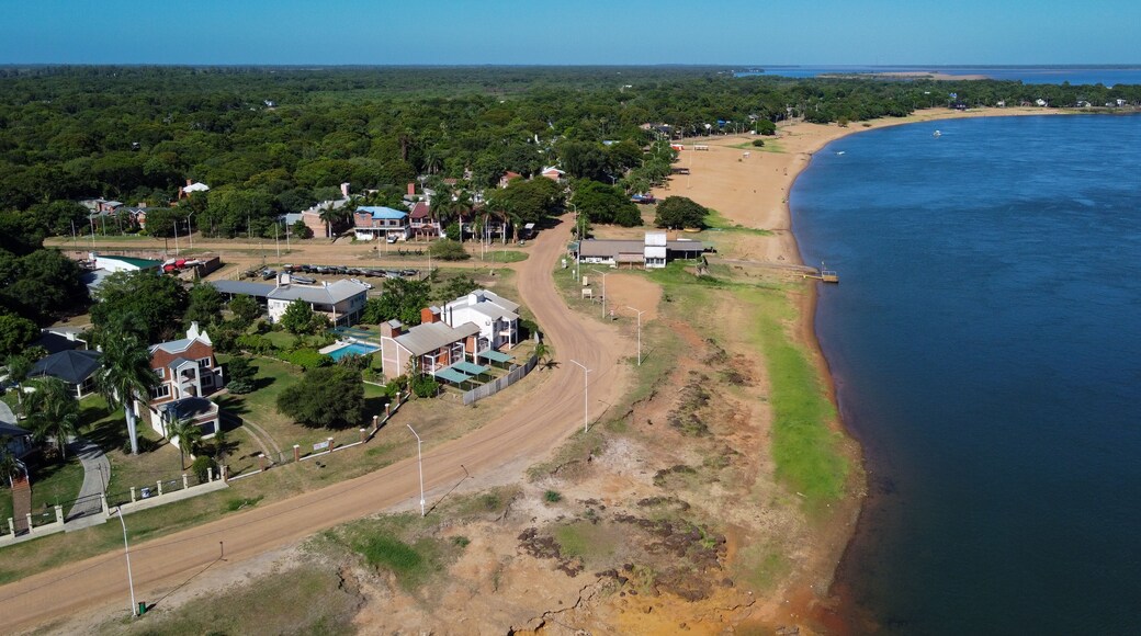 Discover the harmony of Paso de la Patria. The waterfront curve reveals sunny beaches, residences, and leisure spaces, a perfect day in Corrientes.