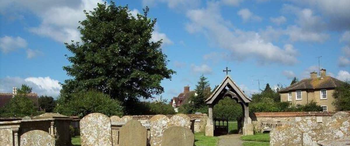 A cemetery with stone headstones and a central archway.