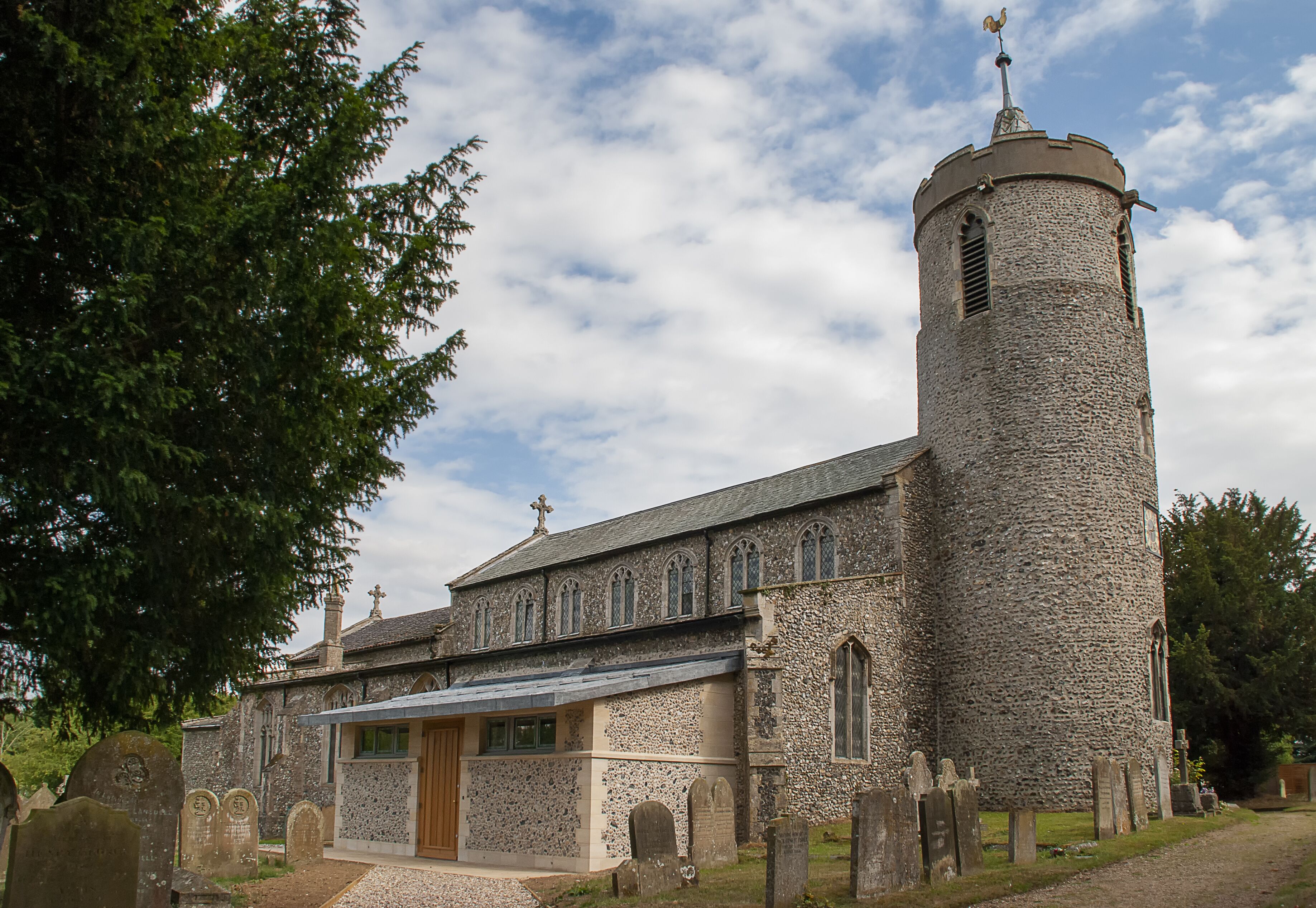 A historic church with a tall stone tower and a traditional wooden door.