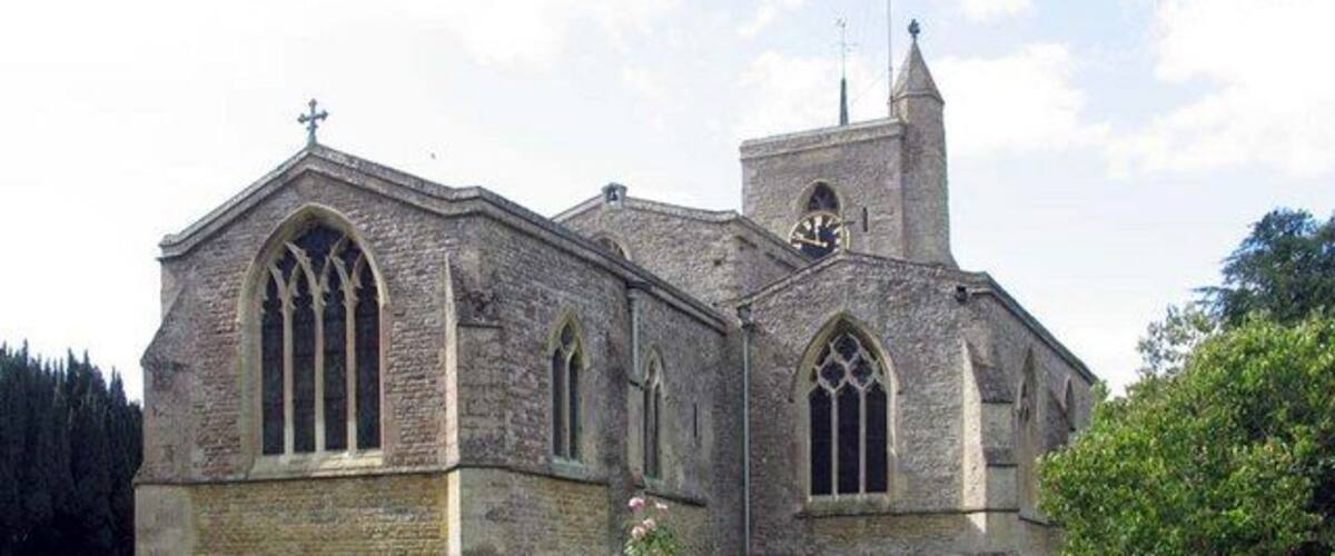Une église en pierre dotée d’un clocher et d’un cimetière situé devant.