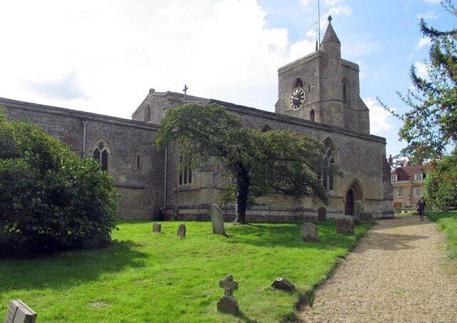 A church with a clock tower, surrounded by a cemetery with gravestones and a grassy path.