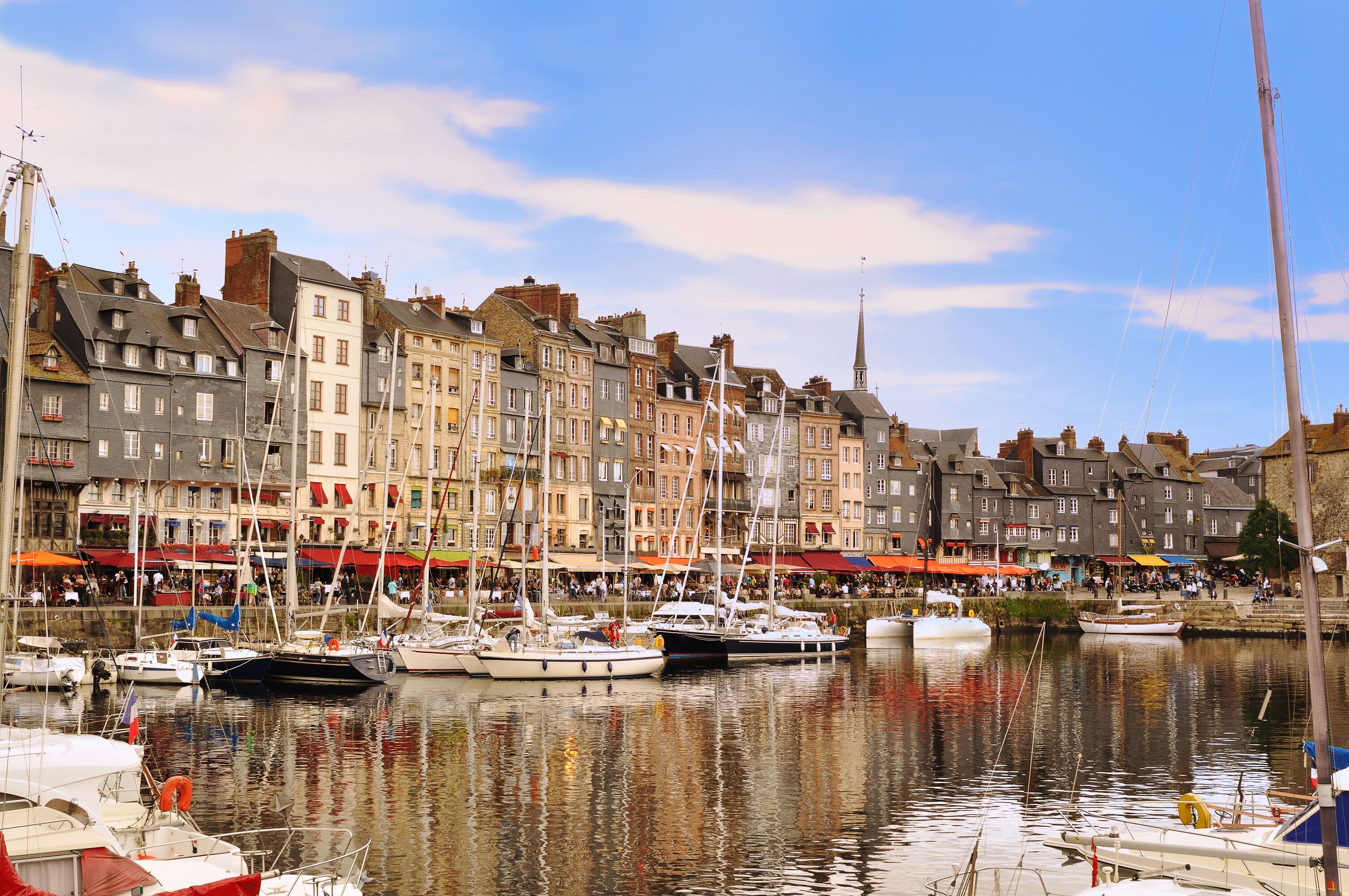 A harbor with boats docked along the waterfront, surrounded by historic buildings with red and white facades.