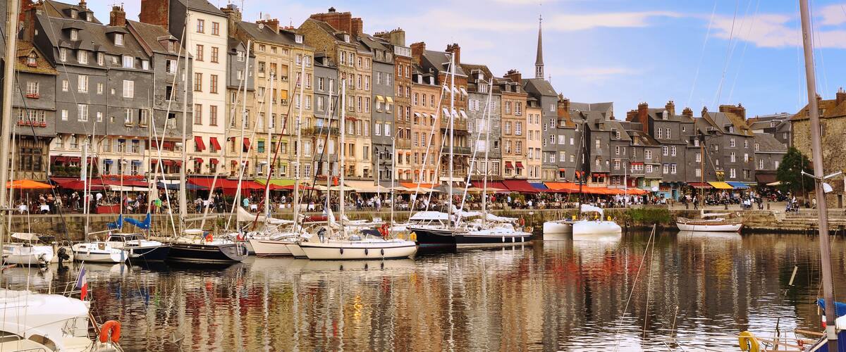 A harbor with boats docked along the waterfront, surrounded by historic buildings with red and white facades.