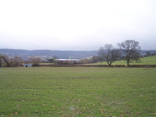 Droys Court. Looking south east over the fields to the farm buildings with the Cotswold escarpment at Birdlip in the distance.