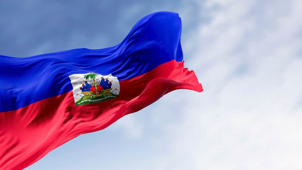 A flag with a blue field, a white field with a coat of arms, and a red field.