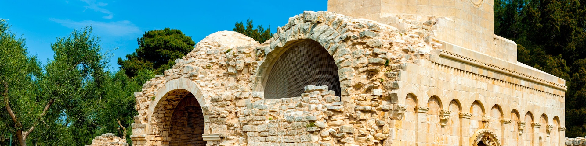 An ancient stone structure with arched doorways and a dome.