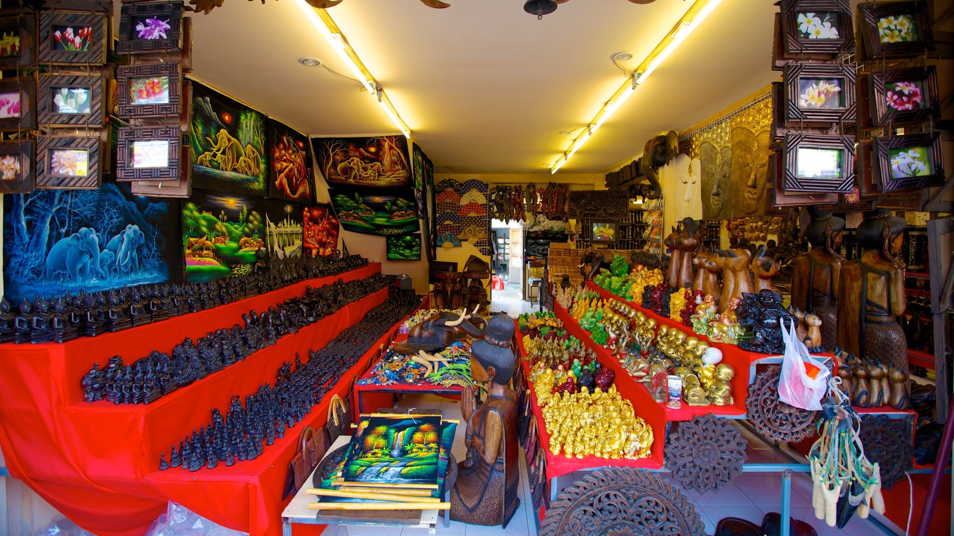 Um mercado vibrante com diversos quiosques exibindo artesanato, tecidos e artigos decorativos.