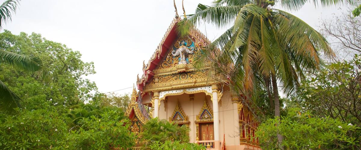 Un templo tradicional con arquitectura ornamentada, rodeado de exuberante vegetación y palmeras.