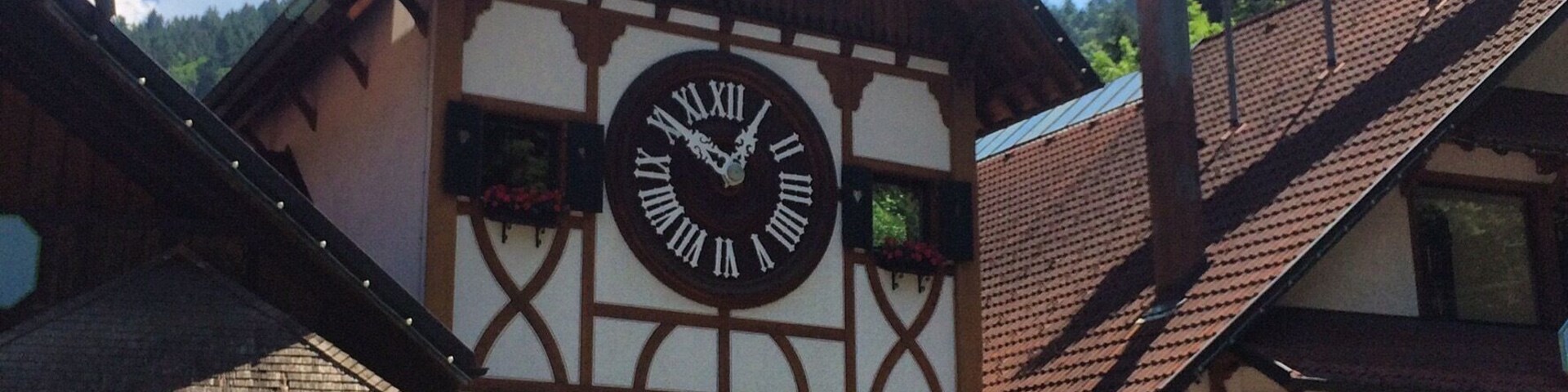 Un edificio tradicional con entramado de madera, un gran reloj, una veleta y un letrero que dice 'eClé'.