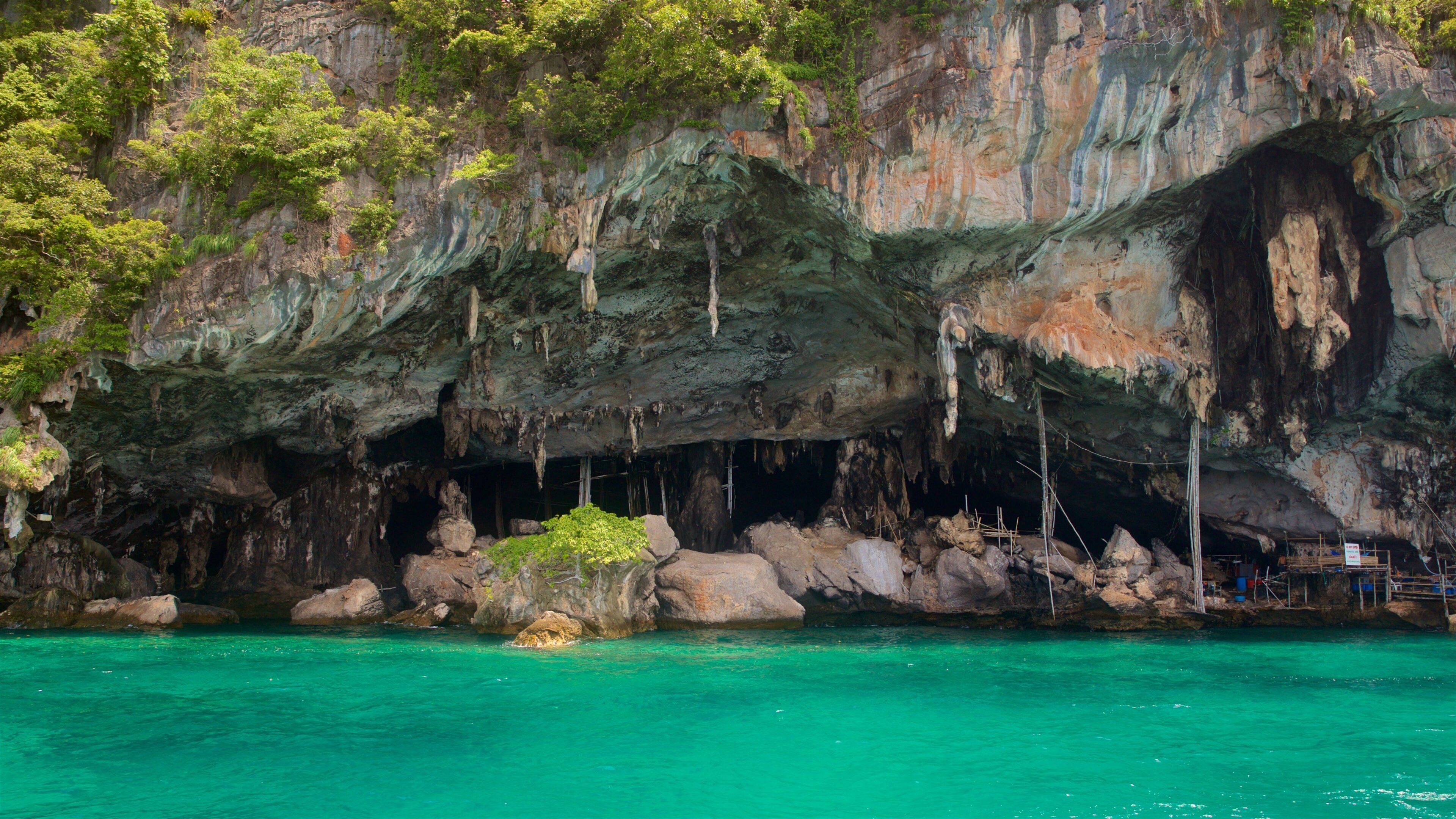 A cave entrance with turquoise water and rocky cliffs.