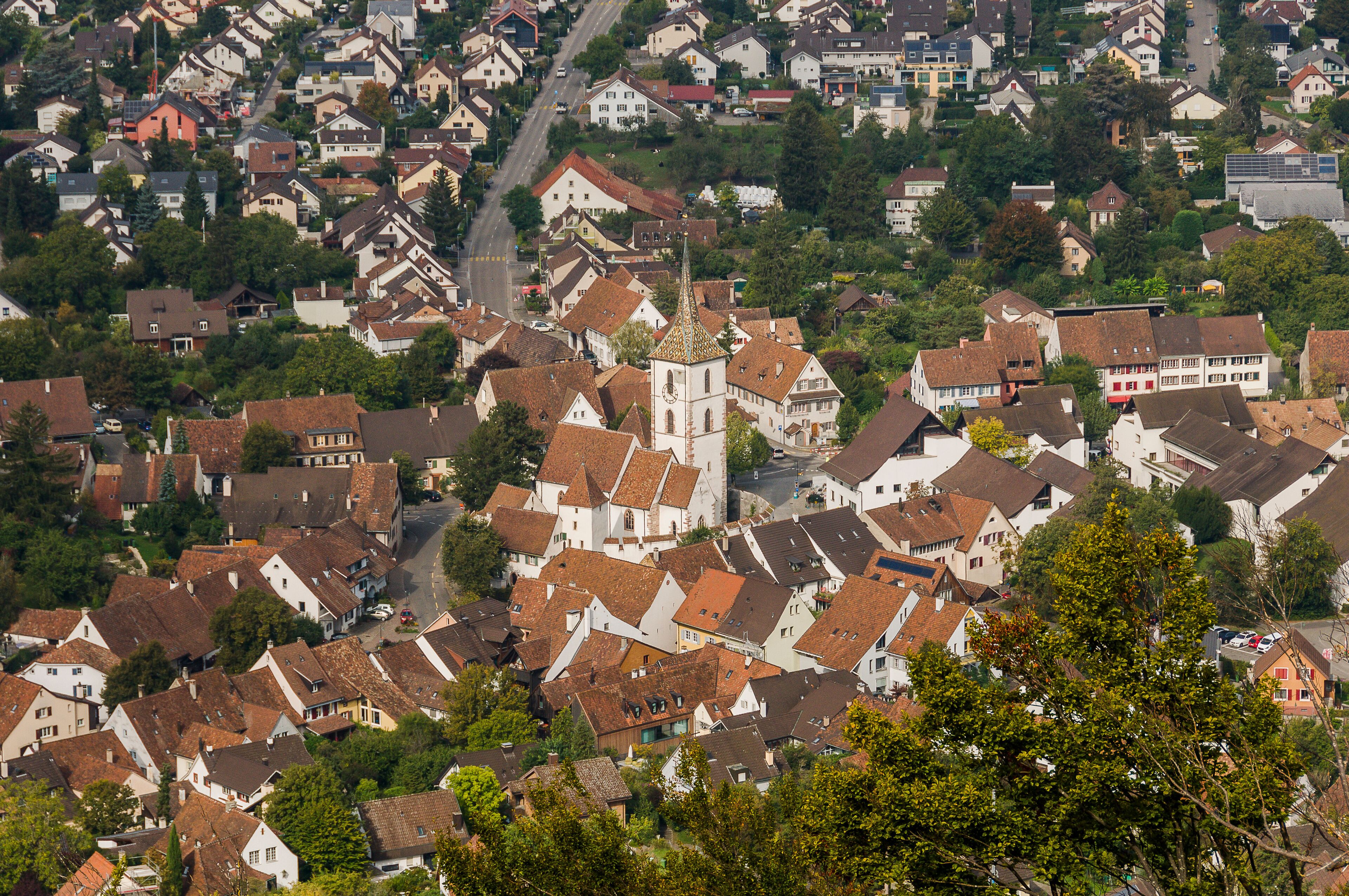 A densely packed town with historic buildings and a prominent church steeple.