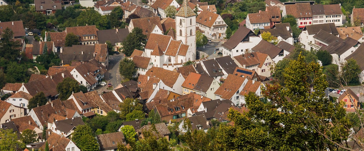 A densely packed town with historic buildings and a prominent church steeple.