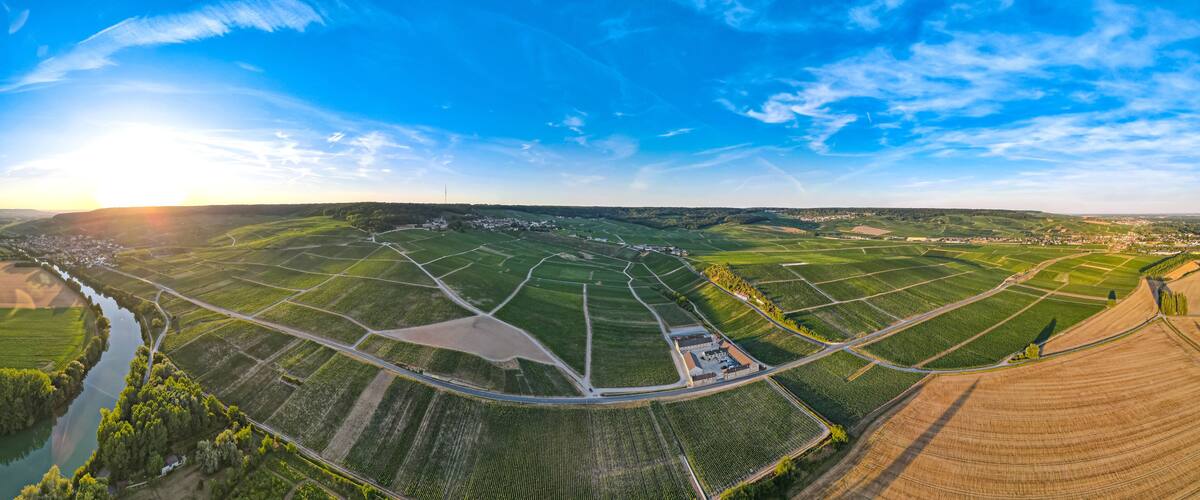 An aerial view of a rural landscape with fields, a river, and a small town.