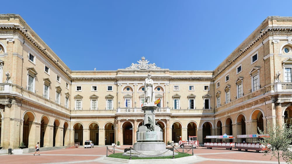 Recanati, Italy - August 21st, 2018: Giacomo Leopardi square. The municipal building is behind the statue of the poet