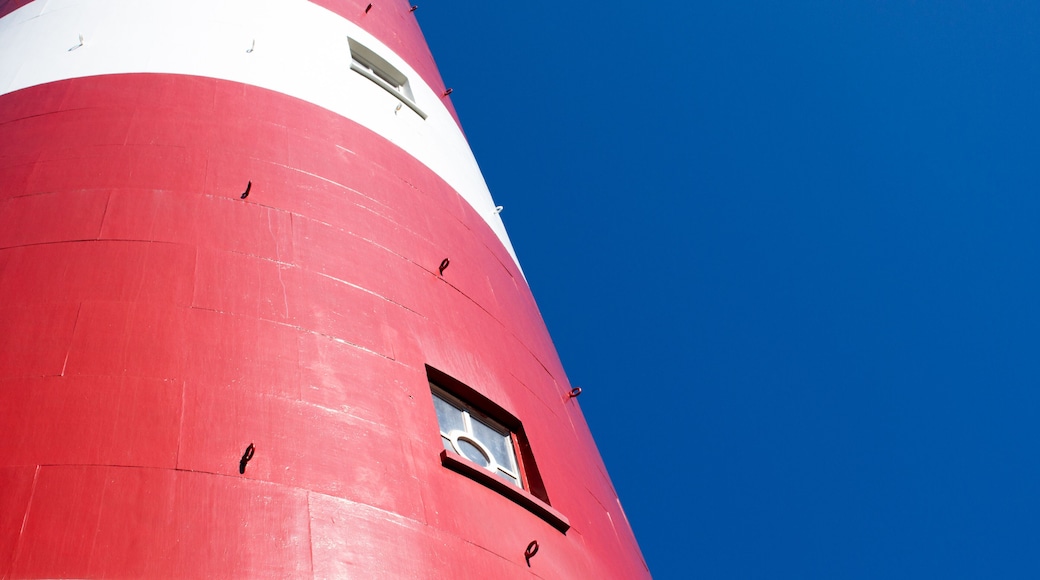 detail of a red and white lighthouse with blue sky in the background