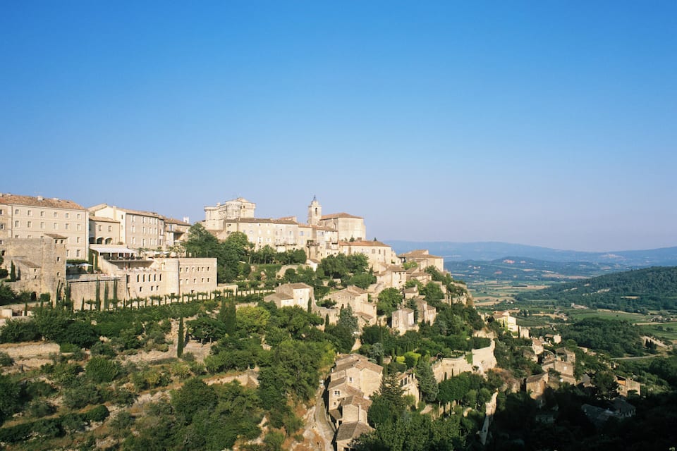 A historic town perched on a hillside with ancient buildings and lush greenery.