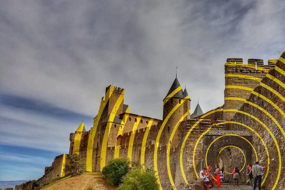 Un castillo histórico con franjas amarillas y una escalera de caracol.