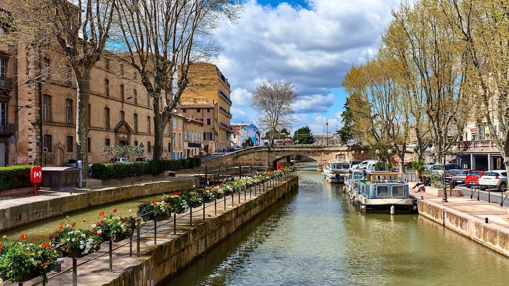 Ein Kanal mit Booten, einer Brücke und historischen Gebäuden am Ufer.