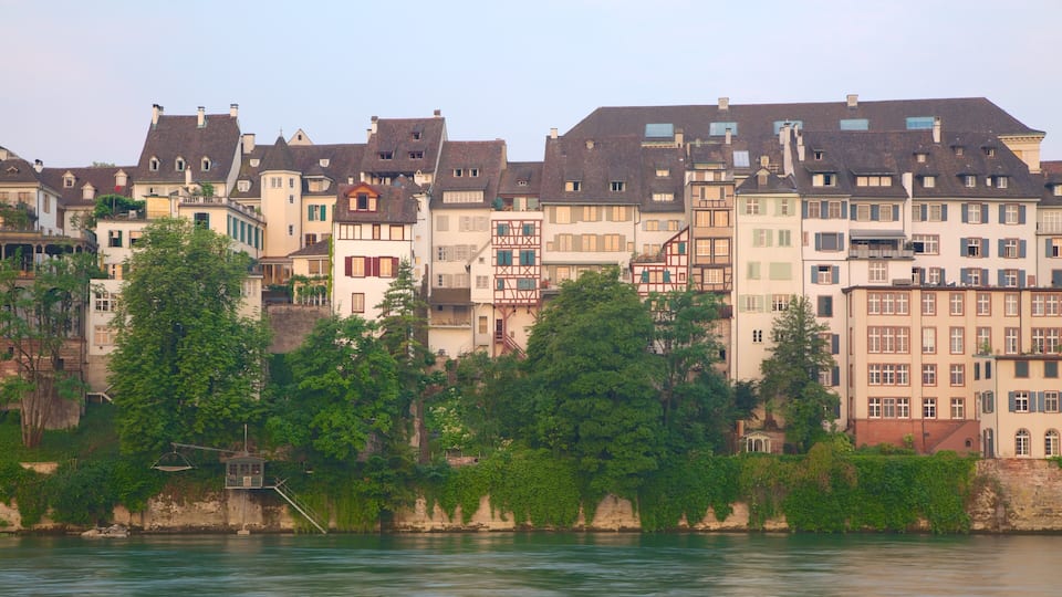 A riverfront with historic buildings and lush greenery.