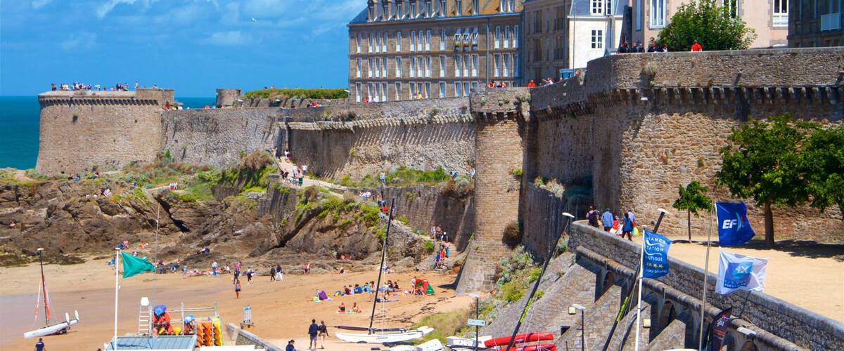 A coastal town with a historic fort, beach, and traditional buildings.