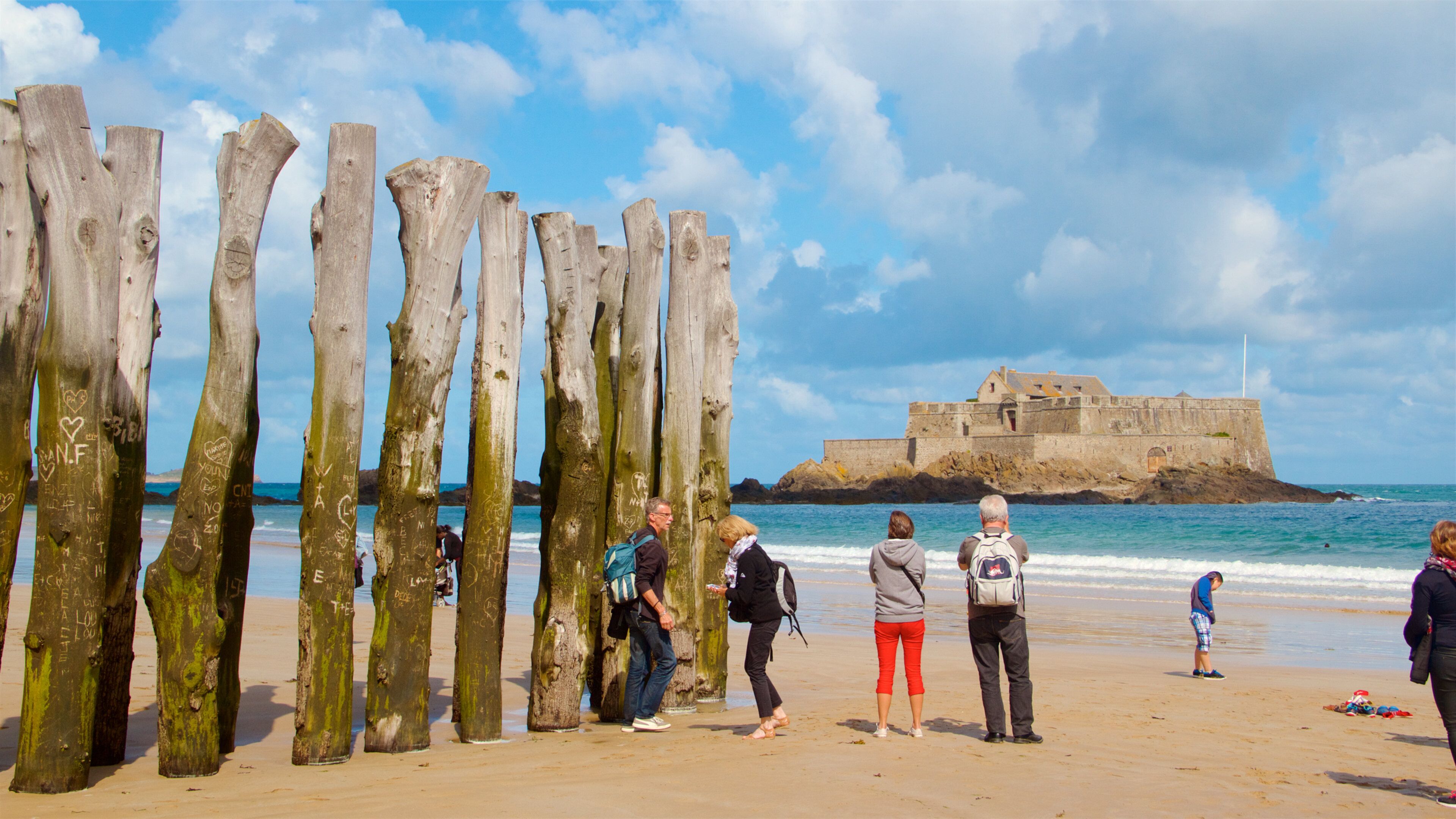 Ille-et-Vilaine featuring a beach and general coastal views as well as a small group of people