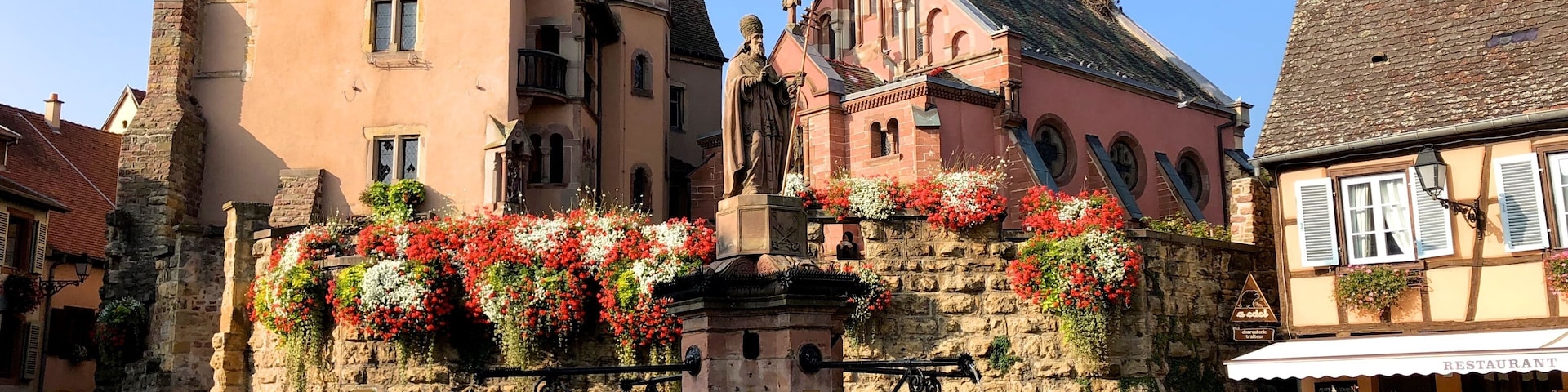 Designated as one of France's "Plus Beaux Villages," the picture-perfect village of Eguisheim is nestled in a sunny valley surrounded by the green rolling foothills of the Vosges Mountains. This enchanting medieval village was founded in 720 by the Count Eberhard. Just a short distance from Colmar, this typical Alsatian village has narrow cobblestone streets lined with brightly painted half-timbered houses that date from the 16th and 17th century. Ancient inscriptions can still be deciphered on the stone lintels of the houses. These historic houses feature balconies that are lovingly decorated with potted flowers. Because of its exquisite floral displays, the village has been rewarded with the "Grand Prix National du Fleurissement," France's most prestigious national floral award. Visitors will enjoy wandering through the village, admiring the beauty of the buildings, and the colorful geranium-bedecked window sills.
