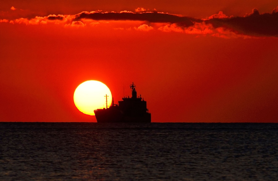 Tombeau Bay, Baie-du-Tombeau, Pamplemousses District, Mauritius, Mascarene Islands, Africa - sunset over Indian Ocean with distant ship seen from Tombeau Bay close to Port Louis and its harbour