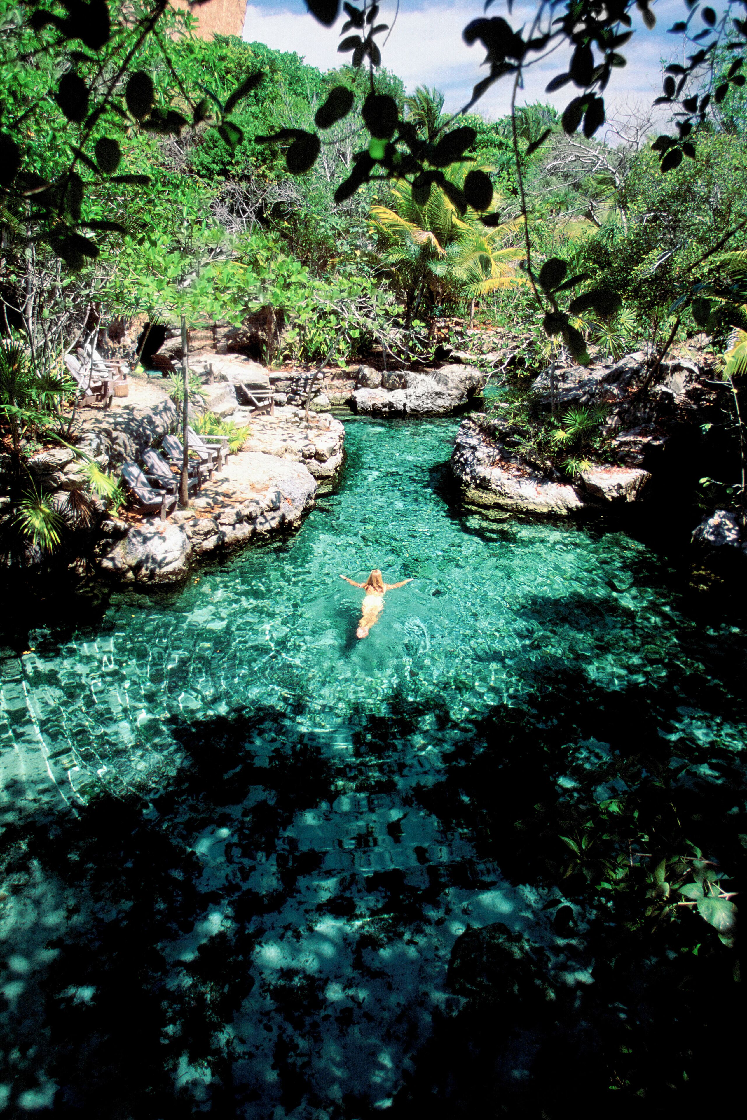 Mexico, Xcaret, Woman swimming in the river