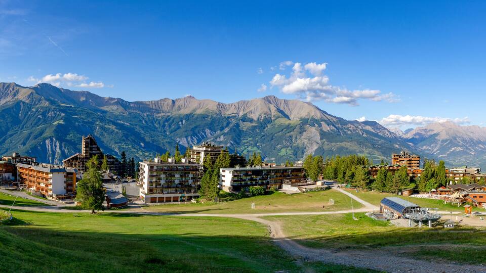 A mountainous landscape with buildings and a ski lift.